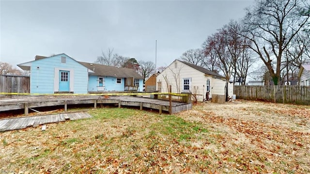 rear view of house with a yard and fence