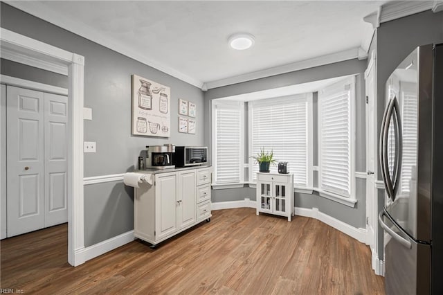 office with baseboards, light wood-style flooring, and ornamental molding