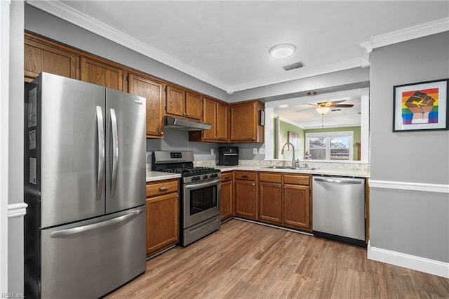 kitchen featuring visible vents, under cabinet range hood, a sink, stainless steel appliances, and light countertops