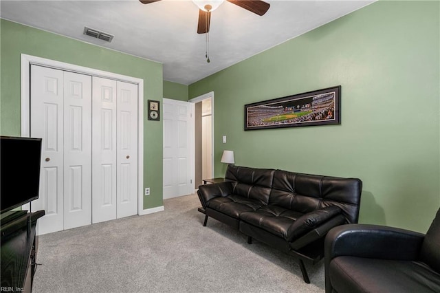 living room with visible vents, carpet floors, and ceiling fan