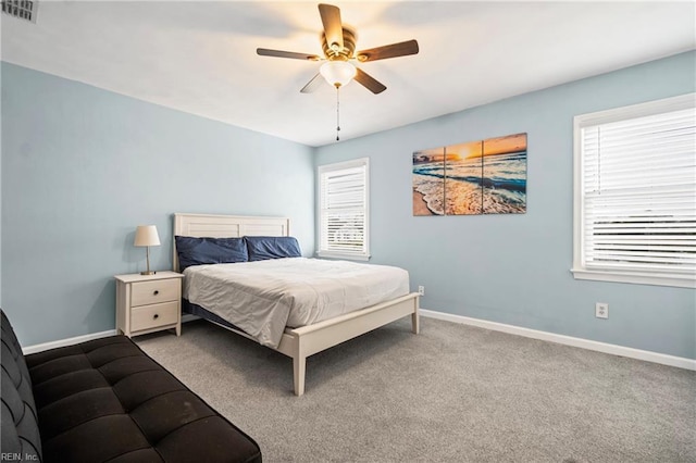 carpeted bedroom featuring visible vents, multiple windows, and baseboards