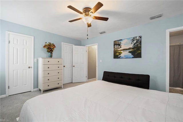 bedroom featuring visible vents, two closets, baseboards, and carpet