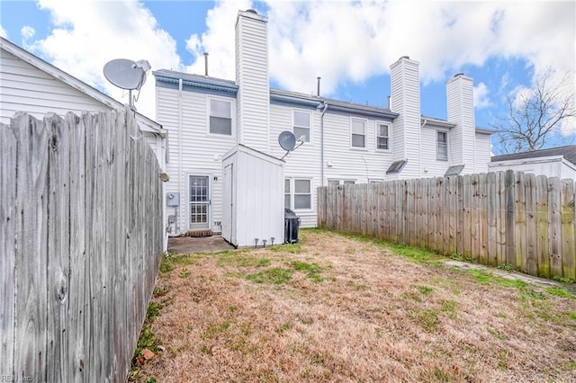 rear view of house with a chimney and fence