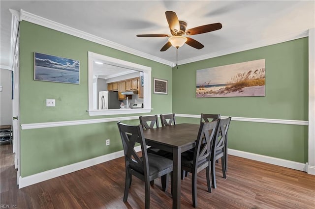 dining space with baseboards, wood finished floors, ceiling fan, and crown molding