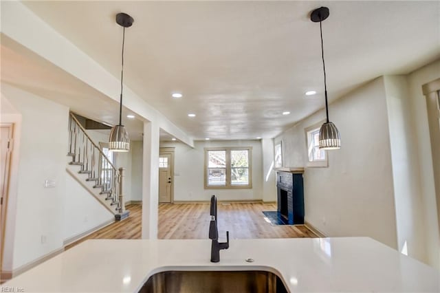 kitchen featuring a fireplace with flush hearth, recessed lighting, open floor plan, and wood finished floors