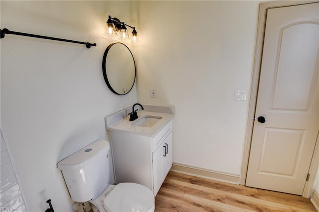 bathroom featuring vanity, toilet, and wood finished floors