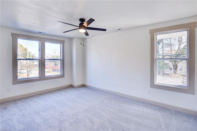 carpeted empty room featuring visible vents, baseboards, and a ceiling fan