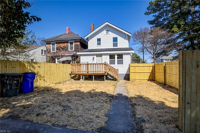 back of property featuring a deck and a fenced backyard