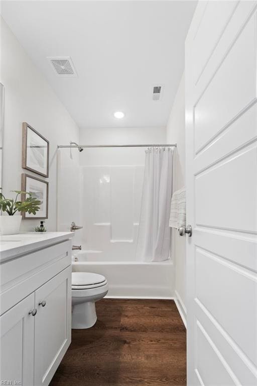 bathroom with vanity, wood finished floors, visible vents, shower / tub combo, and toilet