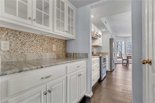 kitchen featuring extractor fan, dark wood finished floors, decorative backsplash, white cabinets, and stainless steel appliances