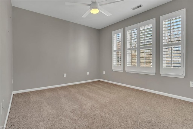 carpeted empty room featuring visible vents, baseboards, and a ceiling fan