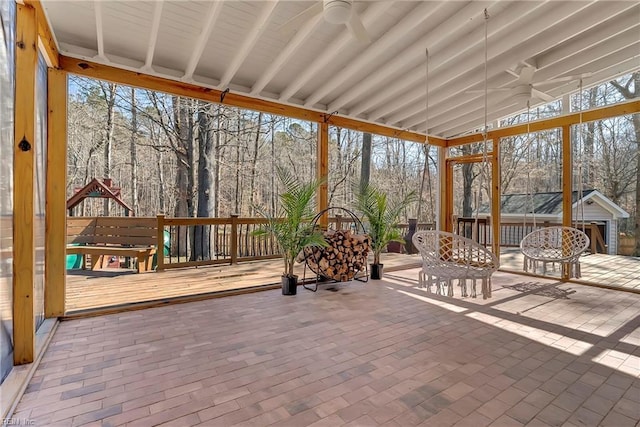 unfurnished sunroom featuring ceiling fan