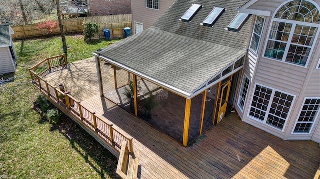 wooden terrace with a lawn and fence