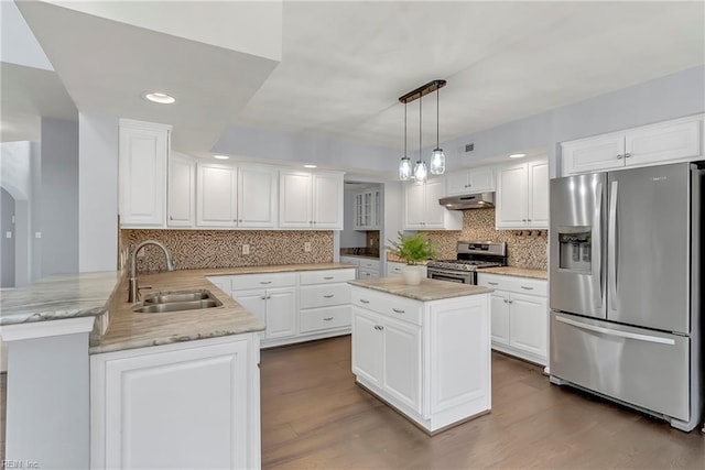 kitchen featuring under cabinet range hood, appliances with stainless steel finishes, a peninsula, white cabinetry, and a sink