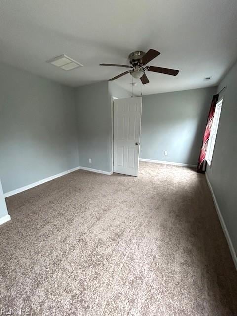 carpeted empty room featuring baseboards and ceiling fan