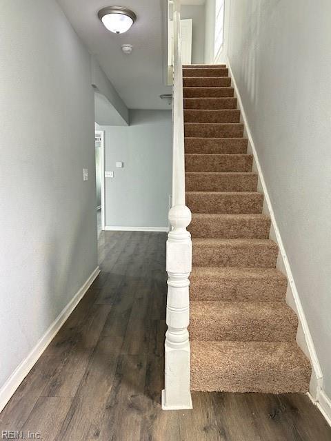 stairway featuring baseboards and wood finished floors