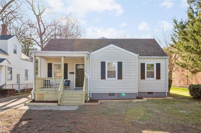 view of front of home with a shingled roof, a porch, a front yard, and crawl space