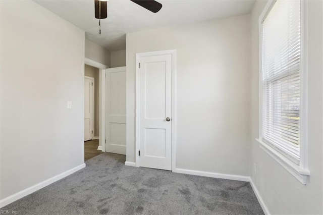 unfurnished bedroom with carpet flooring, baseboards, and ceiling fan