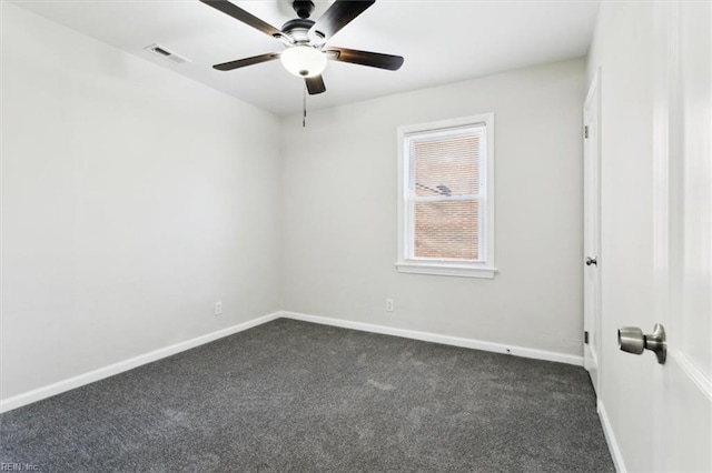 spare room featuring visible vents, baseboards, ceiling fan, and dark carpet