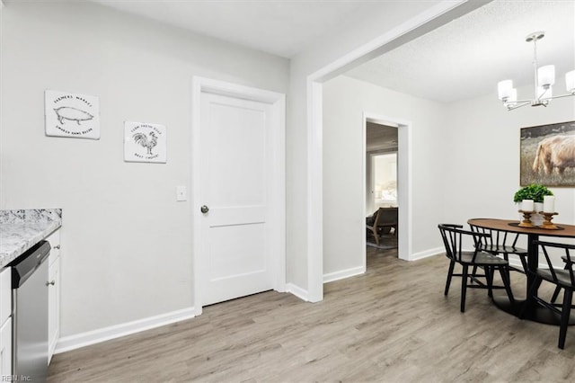 dining room featuring an inviting chandelier, baseboards, and light wood finished floors