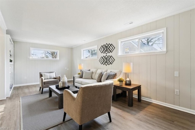 living room with visible vents, baseboards, and wood finished floors