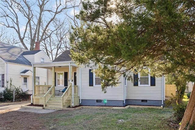 view of front of home with crawl space, a porch, and a front lawn