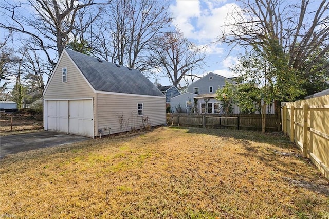 view of yard with a detached garage, fence, and an outdoor structure