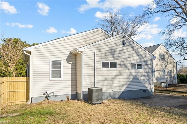 view of property exterior featuring crawl space, a lawn, cooling unit, and fence