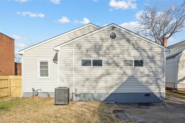 rear view of property with crawl space, central air condition unit, a yard, and fence