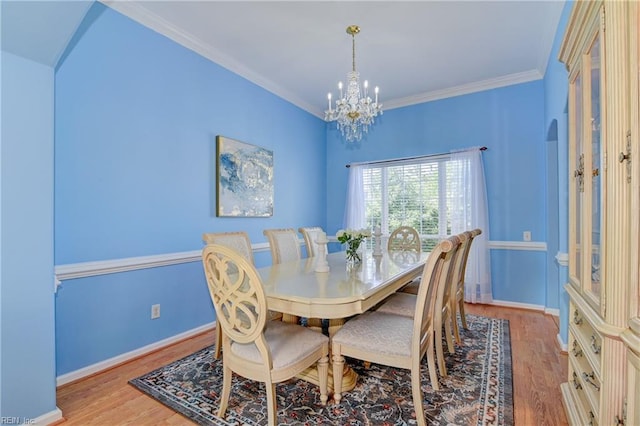 dining space with baseboards, a notable chandelier, wood finished floors, and ornamental molding