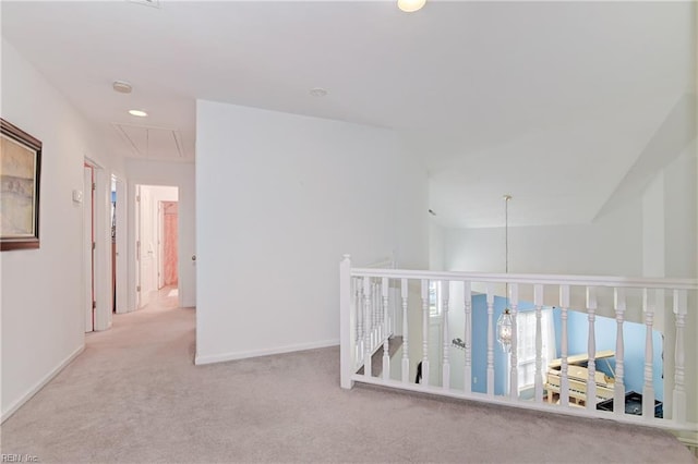 corridor featuring attic access, carpet flooring, and baseboards