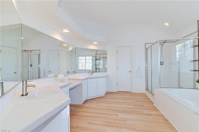 full bath with vaulted ceiling, wood finished floors, a shower stall, and a sink