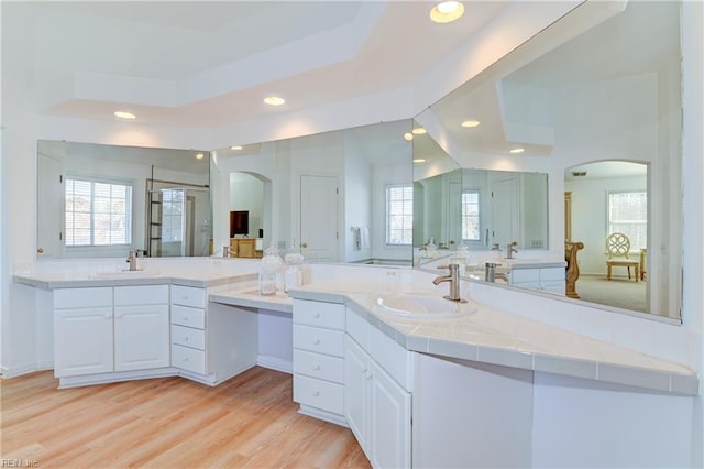 full bath featuring a sink, wood finished floors, a stall shower, and recessed lighting