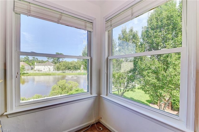 interior space featuring baseboards and a water view