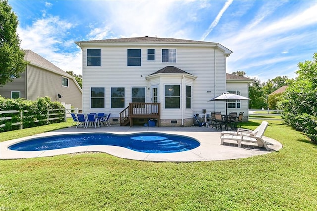 back of house featuring crawl space, a patio area, a lawn, and an outdoor pool