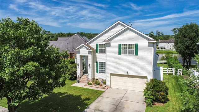 view of front facade featuring a garage, driveway, a front yard, and fence