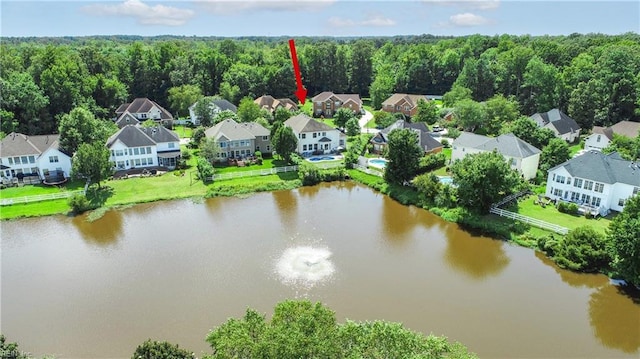 bird's eye view featuring a residential view, a wooded view, and a water view