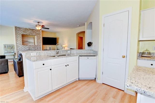 kitchen with a sink, open floor plan, white dishwasher, and white cabinets