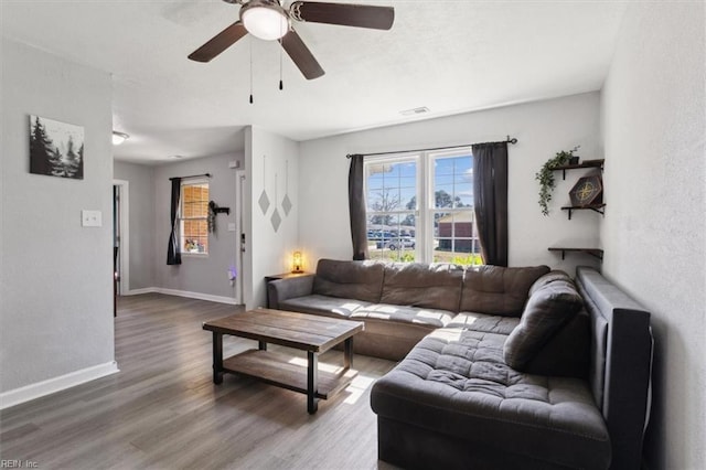 living room with visible vents, ceiling fan, baseboards, and wood finished floors