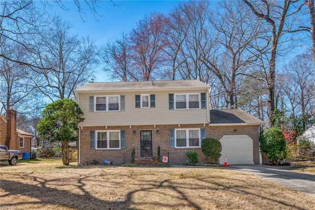 colonial inspired home featuring a front lawn, brick siding, concrete driveway, and an attached garage