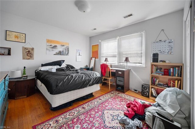 bedroom with visible vents and hardwood / wood-style flooring