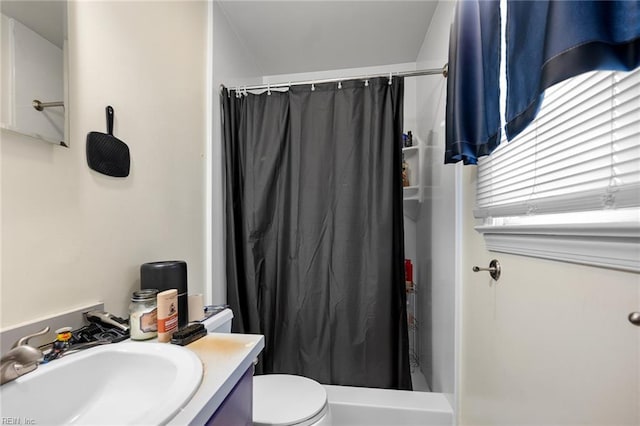 full bath with a shower with curtain, vanity, and toilet