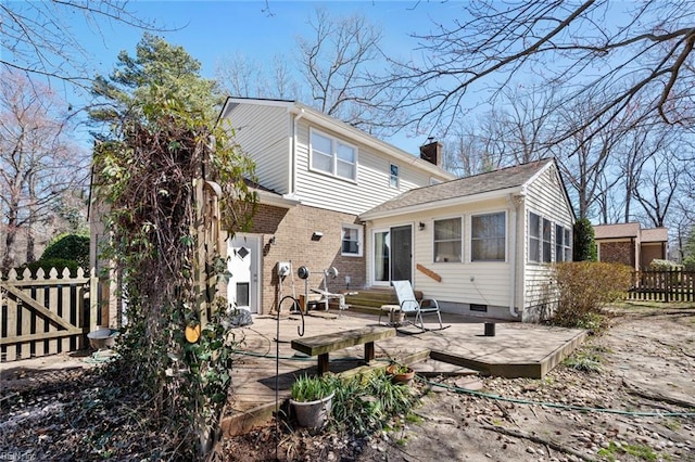 back of property featuring fence, a chimney, entry steps, crawl space, and brick siding