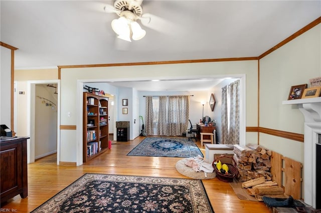 foyer entrance featuring baseboards, hardwood / wood-style floors, a fireplace, and ornamental molding