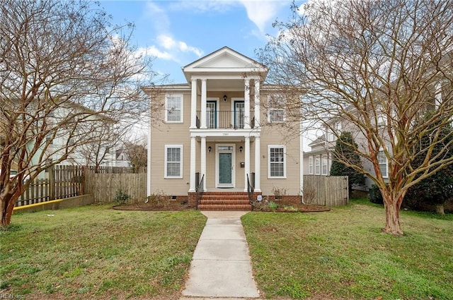 greek revival house featuring crawl space, a balcony, a front lawn, and fence