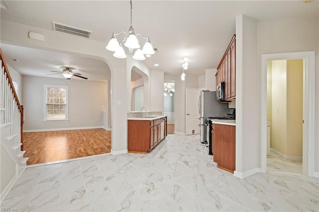 kitchen with visible vents, brown cabinets, stainless steel microwave, open floor plan, and range