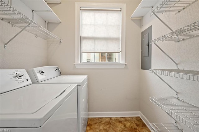 washroom featuring laundry area, electric panel, washing machine and dryer, and baseboards