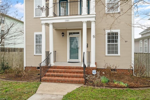 view of exterior entry with crawl space and fence