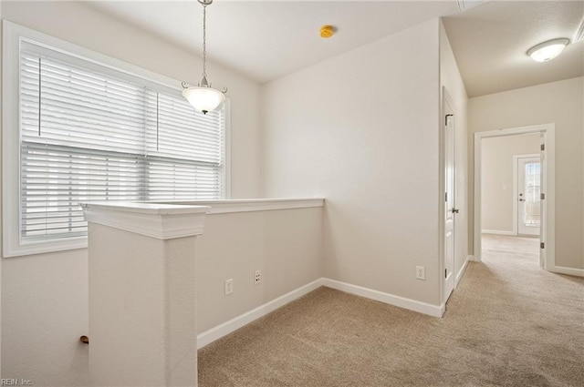 hallway with carpet flooring, plenty of natural light, and baseboards