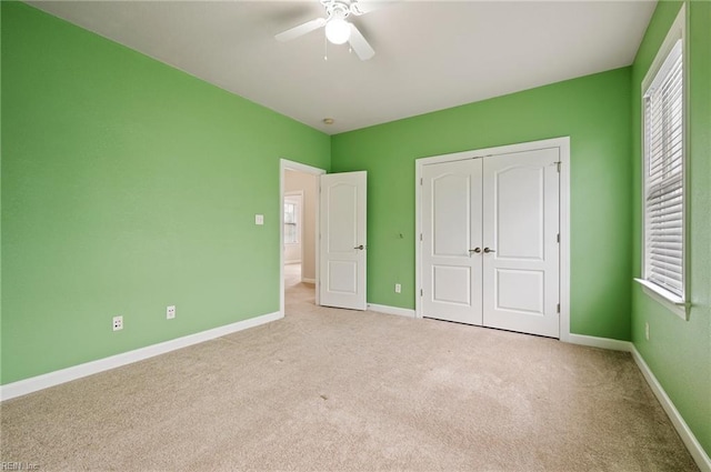 unfurnished bedroom featuring a closet, baseboards, carpet, and ceiling fan